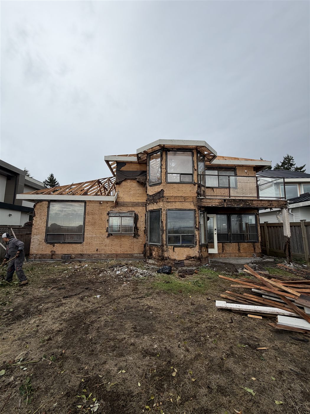 A house under renovation with framing and sheathing exposed, a TAKL Services project in progress